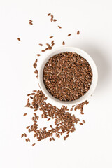 Raw flax seeds in ceramic bowl on white background for Superfood and diet product concept