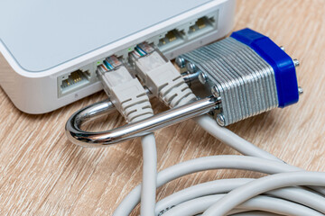 bundle of network Ethernet wires in router locked with metal padlock