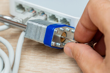 bundle of network Ethernet wires in router locked with metal padlock