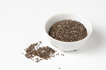 Macro photo of Raw chia seeds in ceramic bowl on white background for Superfood and diet product concept