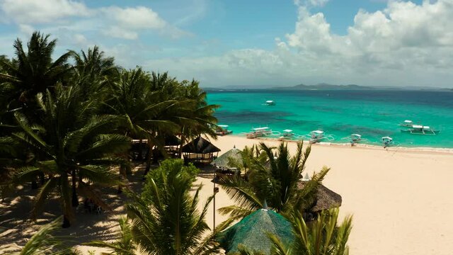 Seascape with beautiful beach and tropical island palm trees by coral reef from above. Daco island, Philippines. Summer and travel vacation concept