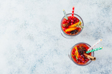 Fototapeta na wymiar Orange and cranberry drinks with orange slices and spices. Hot drinks for winter and Christmas