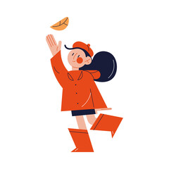 Girl walking and catching falling leaf with hand in autumn