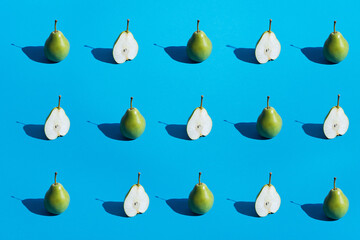 Green fresh sliced pear seamless pattern with dark black deep shadows on blue background flat lay. Minimalistic abstract image. Healthy organic concept. Top view, copy space.