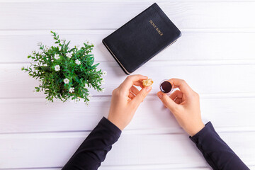 Young woman praying and Taking communion  - the wine and the bread symbols of Jesus Christ blood and body with Holy Bible