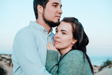 a man and a woman are standing on the beach, smiling, hugging . rest 