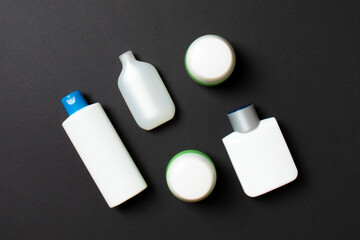 Cosmetics SPA branding mock-up, top view with copy space. set of tubes and jars of cream flat lay on colored background