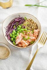 Poke bowl with couscous, baked salmon, bean, and cabbage. Healthy eating concept.