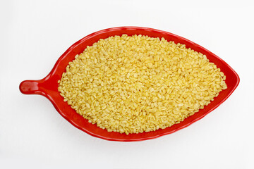 Indian snacks roasted mung dal in red melamine bowl in white background.