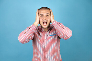 Russian business man over blue background suffering from headache desperate and stressed because pain and migraine with her hands on head