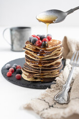 Plate with pancakes and berries on white table