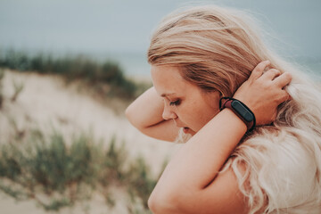 woman blond relaxing on the beach. watch on his arm.