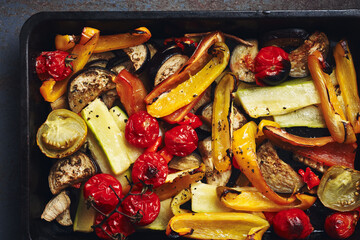 Roasted sliced vegetables on a baking tray.