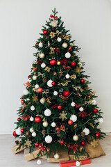 Christmas tree with gifts for the new year in the interior of the white room