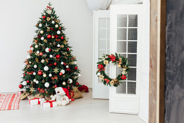 Christmas tree with gifts for the new year in the interior of the white room