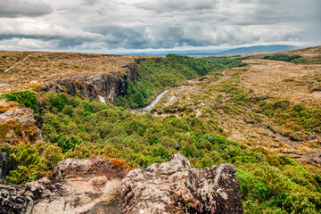 Fototapeta na wymiar Panoramic view of hiking trails and mountain stream in Tongariro National Park, North Island, New Zealand