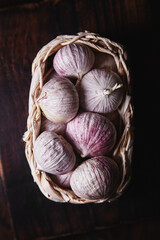 young garlic in a braided basket on a dark background in a rustic style
