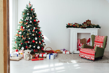 Christmas tree with gifts of garland lights for the new year in the interior of the white room as a backdrop