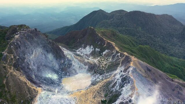 Cinematic aerial shot flying over crater lake in volcano Mount Sibayak in North Sumatra, Indonesia