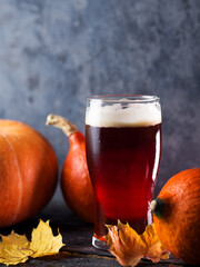 Pumpkin autumn craft red ale beer in a glass on the table