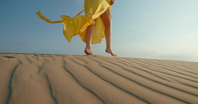 Fashion dress slow motion. Commercial footage for clothing business. Beautiful bright dress is waving on wind. Cinematic modern shot of yellow fabric flattering on blue background. Desert nature 4K