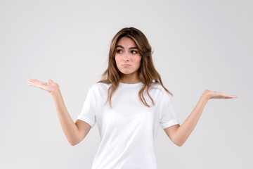 Portrait dumb looking woman arms out shrugs shoulders who cares so what I don't know, isolated on white background. Negative human emotion, facial expression body language life perception attitude