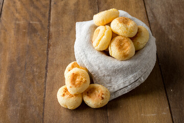 Traditional Brazilian Snack Cheese Bread in a pot. On a wooden table background. copy space