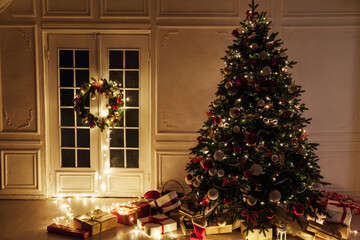 Christmas tree with gifts of garland lights for the new year in the interior of the night room as a backdrop