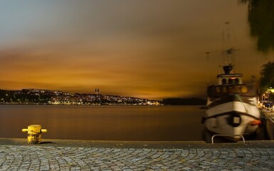 Night view in Stockholm, ship blurred on the photo as water moves it during the long exposure, making a ghostly appearance