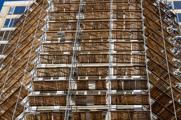 building under construction with scaffolding with sun light
