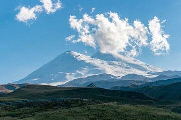 Obraz na płótnie Canvas Scenic view of the highest peak in Europe, mount Elbrus with green hills on a Sunny summer day.