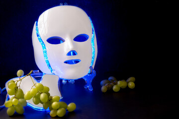 Color therapy mask glowing blue with grapes
