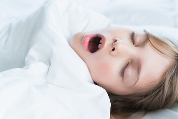 Little snoring girl, sleeping on pillow in bed with closed eyes. Evening late going to bed. Early...