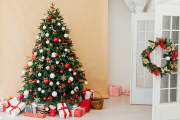 Christmas tree pine decorated with toys with gifts in the interior beige background new year