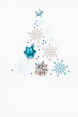 Christmas or New Year's composition 2021. Beautiful xmas tree made of blue and silver decorations on a white background and copy space. Greeting card mockup. Flat lay
