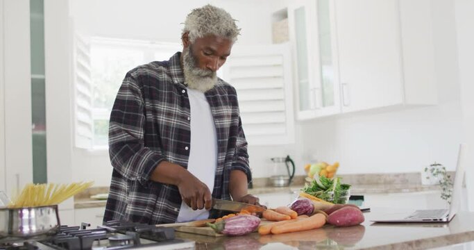 Senior man chopping vegetables in the kitchen