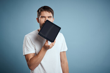 man with touch tablet in hands on blue background gesturing with hands cropped view copy space emotions model