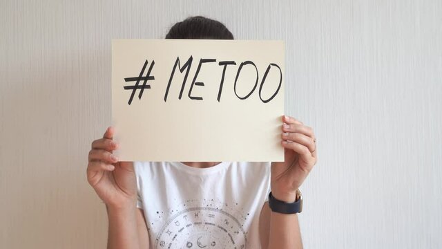 Young woman holding sign with metoo hashtag text. Sexual abuse, equal gender right. 