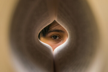 Eye of a woman in the middle of a book