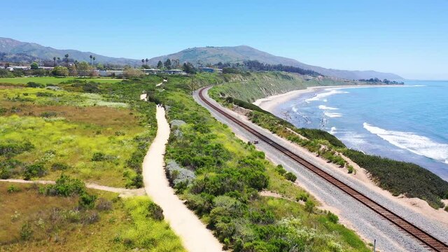 Aerial over coastal trail, railroad tracks and the Pacific coast near Carpinteria, Santa Barbara, California. 