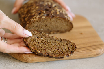 Presentation of a piece of bread with seeds on a wooden cutting Board, showing bread