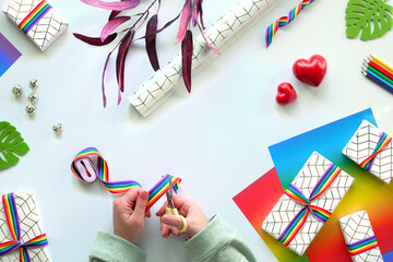 Wrapped gift boxes with LGBT rainbow ribbon. Flat lay with Christmas or Valentine's day decor.