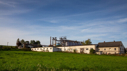 Fototapeta na wymiar Old farm in Poland with grain silo under the blue sky