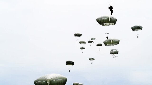 Paratroopers as they float down and land in a field near Sainte-Mere-Eglise, France for the 75th commemoration of D-Day, 2019