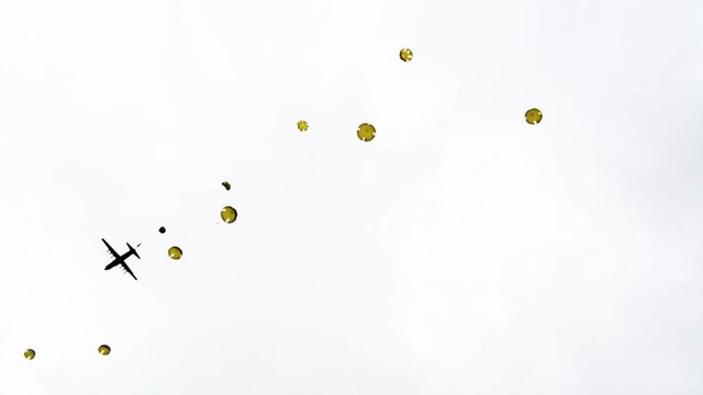 Paratroopers as they jump out of a World War II era plane one by one near Sainte-Mere-Eglise, France for the 75th commemoration of D-Day, June 9th, 2019