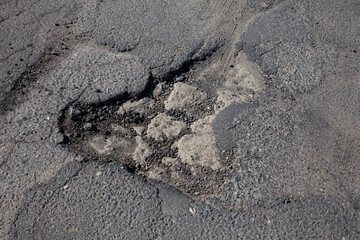 road full of holes in the asphalt. Bumpy.
