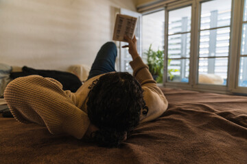 Young man reading a book at home