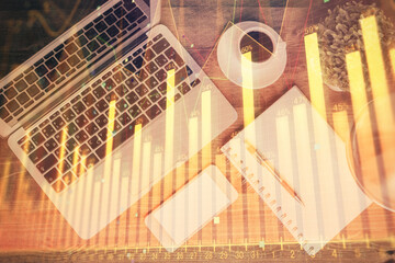 Financial market graph and top view computer on the desktop background. Double exposure. Investment concept.