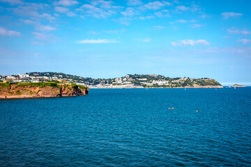 Permian red sandstone cliffs in the town of Torquay Devon England UK showing strata and a...