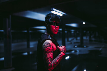 Cyberpunk style. Tattooed guy in one city. Cyber glasses.